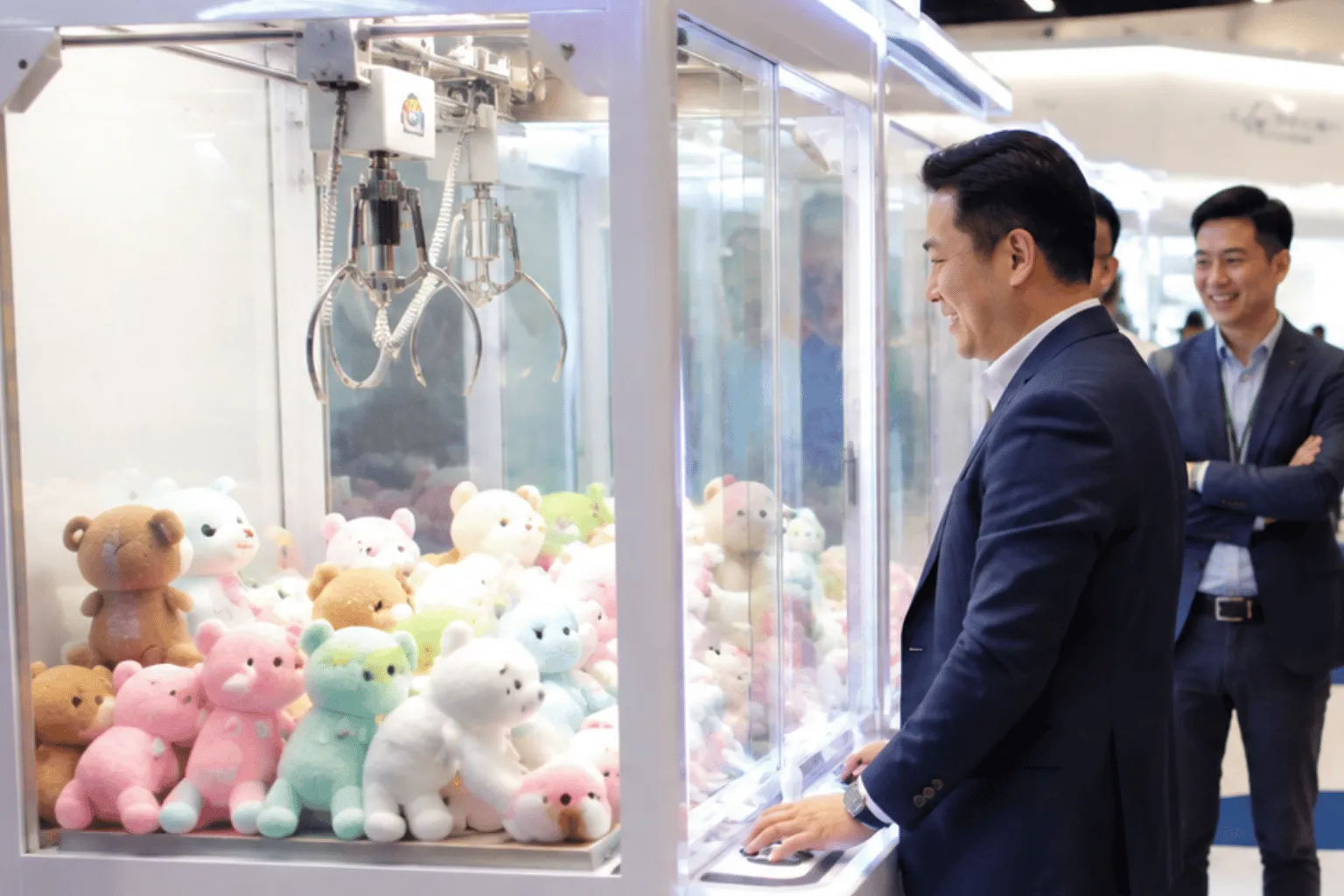 Business attendees gather around a prize machine during a corporate exhibition using claw machine rental in Singapore to encourage booth engagement