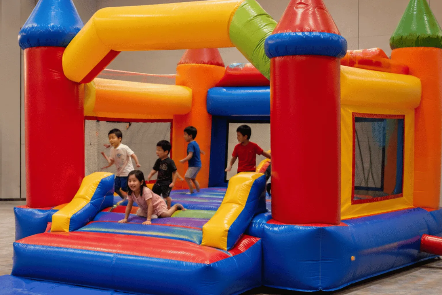 Children play inside a colourful inflatable attraction supplied through bouncy castle rental in Singapore at a spacious indoor venue