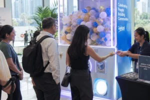 Guests queue beside a large capsule machine while a staff member hands out tokens during a gashapon machine rental in Singapore event